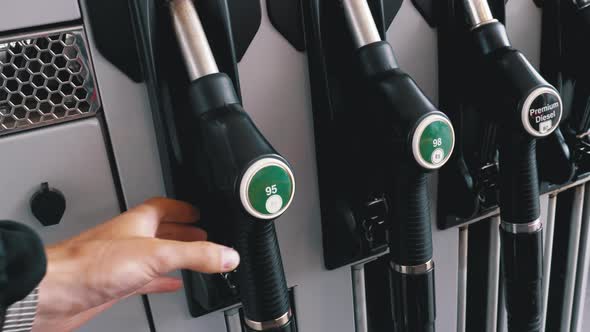 Man's Hand Taking the Fuel Nozzle at Gas Station.