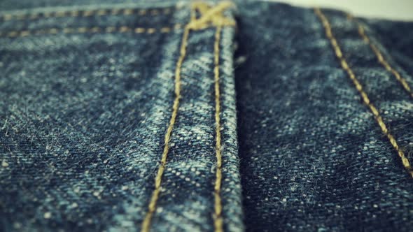 Extreme detailed of blue denim jeans texture in dolly shot over cloth surface.