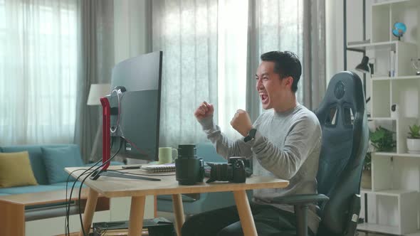 Asian Cameraman Being Happy Finishing Editing Photos By Desktop Computer While Working At Home