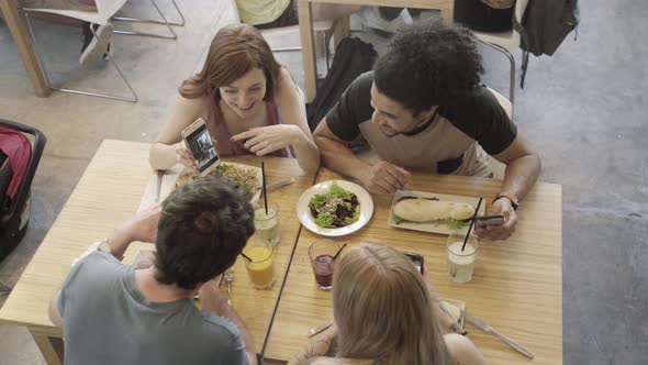 Woman showing smart phone to friends