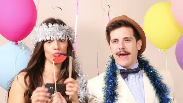 Slow motion of cute couple having fun in party photo booth