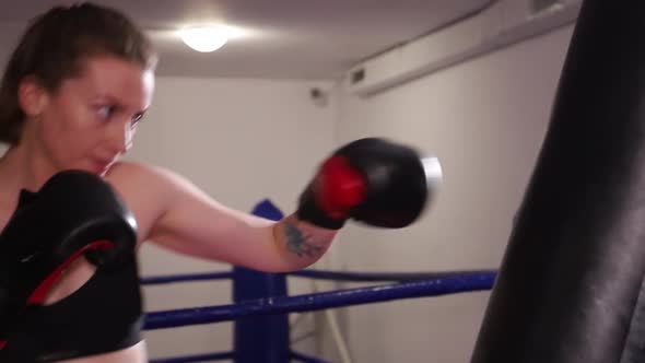 Beautiful Woman with Boxer Trains Punches in the Ring