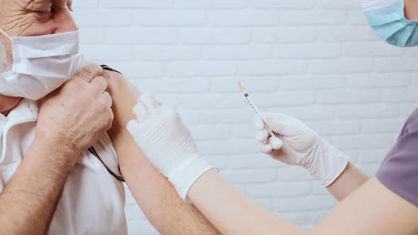 Nurse Giving Vaccine for Senior Man in Clinic