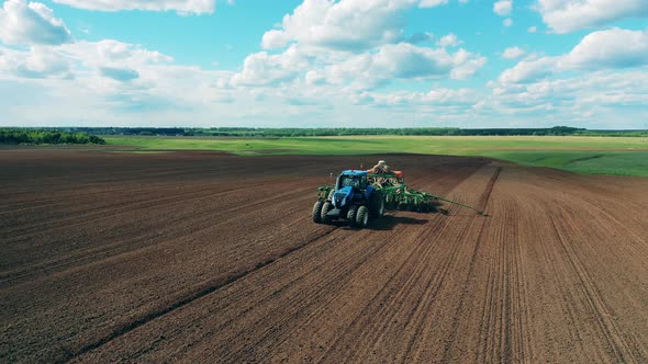 Working Machine Plows Ground with Equipment.