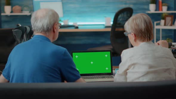 Senior Couple Using Laptop with Green Screen in Living Room