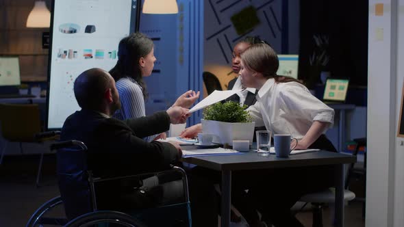 Handicapped Paralyzed Manager Man in Wheelchair Sitting at Conference Table