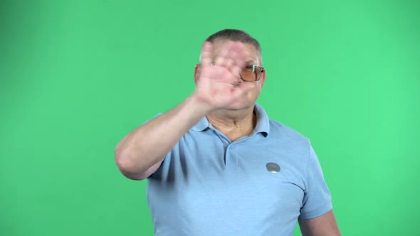 Portrait of Aged Man Waving His Hand and Showing Gesture Come Here, Isolated Over Green Background