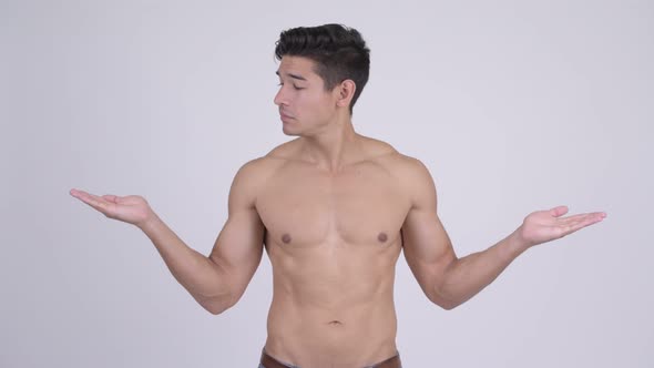 Happy Young Handsome Muscular Shirtless Man Comparing Something