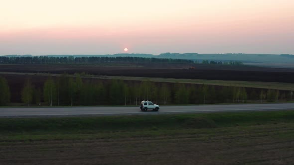 Aerial View of the Car Driving on the Road Against the Background of the Forest
