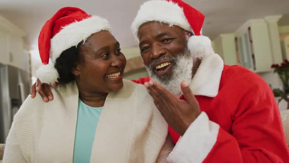 Portrait of african american couple at christmas time wearing santa hats