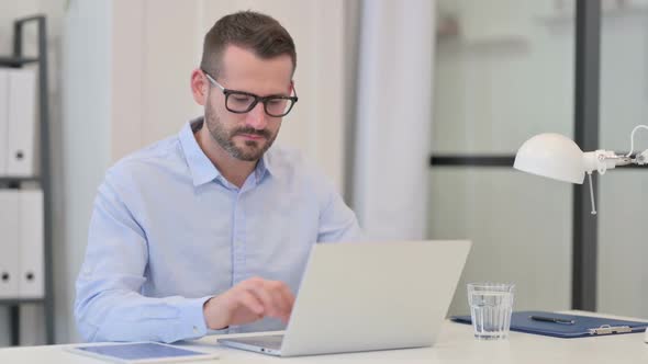 Middle Aged Man Feeling Shocked While Working on Laptop