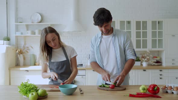 Young Happy Couple Is Enjoying and Preparing Healthy Meal in Their Kitchen