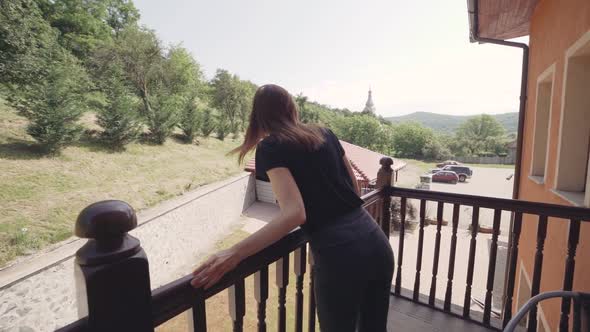 Beautiful Young Woman Relaxing on Balcony