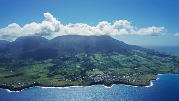 Aerial footage of Mount Liamiuga on a green island with forests and town in Saint Kitts and Nevis