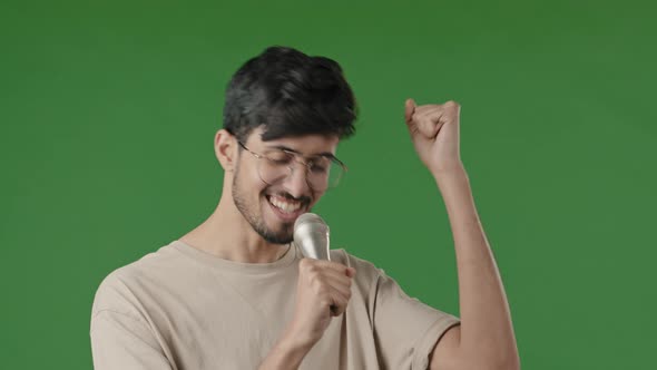 Arab Male on Green Background in Studio Singing Karaoke Use Microphone Closeup Joyful Young Man with