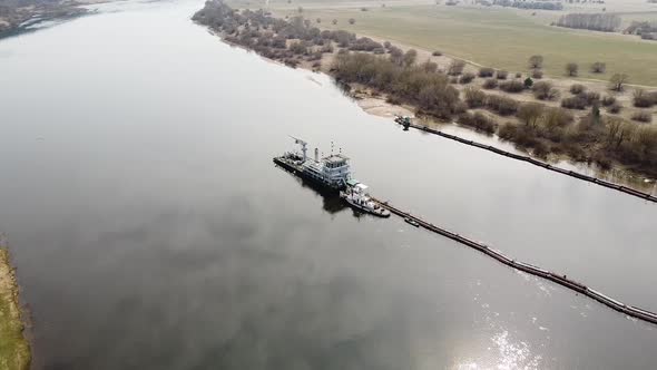 Dredger deepening Nemunas river in aerial side shot, Lithuania