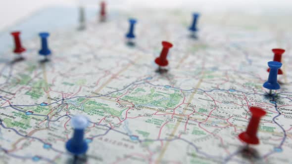 Camera pan revealing red white and blue pins placed marking cities on a US map focusing on the west