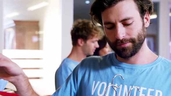 Volunteer selecting clothes from clothes rack