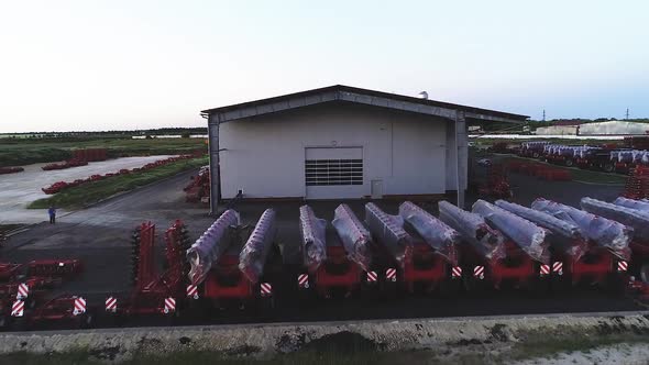 The Territory of an Industrial Plant. Large Hangars with a Red Roof. Aerial View, Evening Shooting