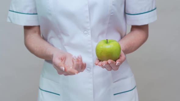Nutritionist Doctor Healthy Lifestyle Concept - Holding Green Apple and Medicine or Vitamin Pills