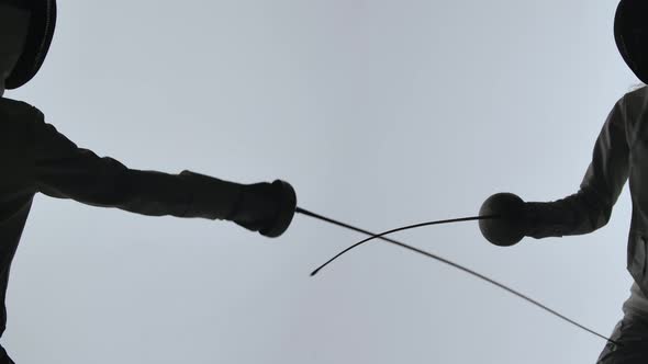 Side View Hands of Female Fencers with Rapiers Close Up on Grey Studio Background