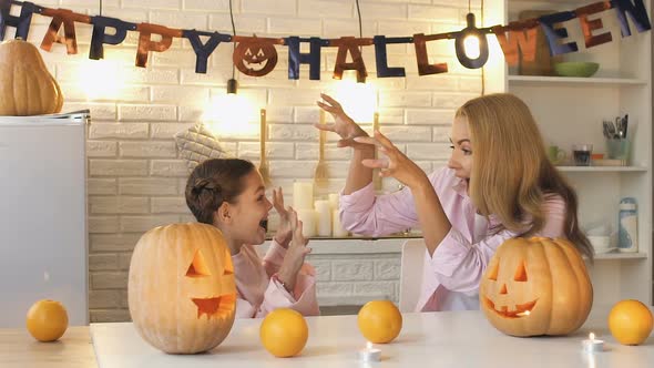 Funny Mother Scaring Her Little Daughter Preparing Pumpkin for All Hallows Eve