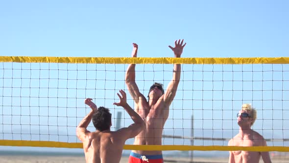 Men playing beach volleyball.