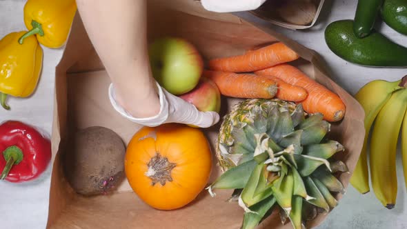 Woman Hand Put Fruits and Vegetables Into Cardboard Bag