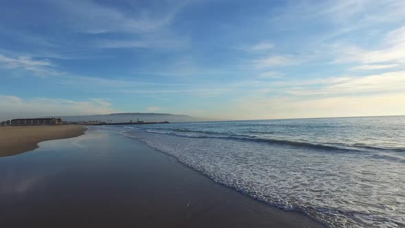 Aerial shot of a scenic beach shoreline at sunset.