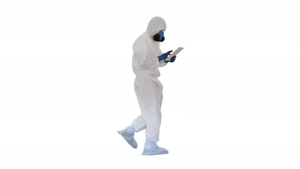 Scientist or Docrot Wearing Biohazard Suits and Protective Masks Using Digital Tablet While Walking