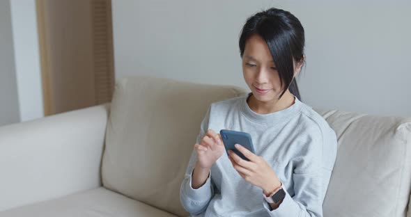 Woman use of mobile phone online at home