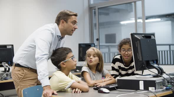 Computer Science Teacher Discussing Task with Schoolchildren