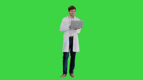 Male Doctor in White Coat Having Video Conference on His Laptop on a Green Screen, Chroma Key.