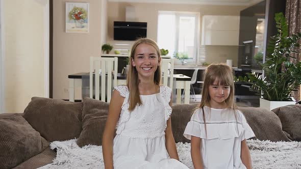 Happy Two Teens Sisters Falling on Bed at Hotel Room alt