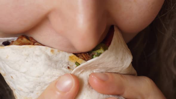 Young Woman Eating Fast Food Biting Vegan Burrito With Vegetables. Closeup Of Female Mouth.