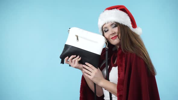 Girl In Santa Hat Holds Gift Handbag. Christmas