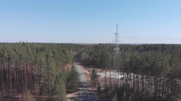High-voltage electricity power lines in green forest. Transmission tower