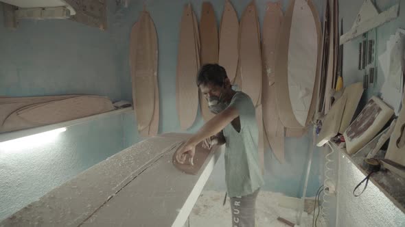 Artisan Making New Surfboard in Workshop