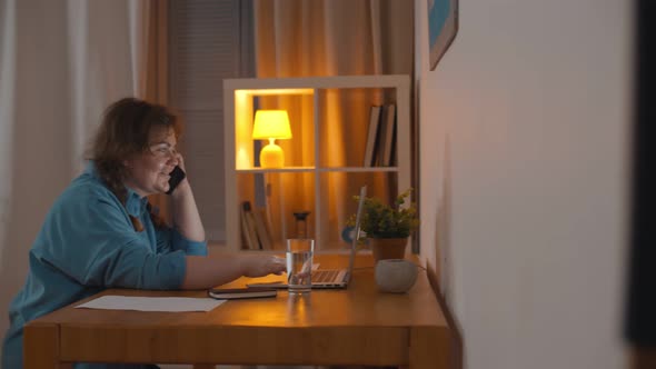 Woman Talking on Phone and Surfing Internet on Laptop with Boyfriend Working on Computer