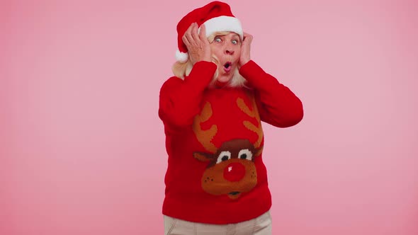 Grandmother in New Year Deer Sweater Raising Hands in Surprise Shocked By Sudden Victory Wow Emotion