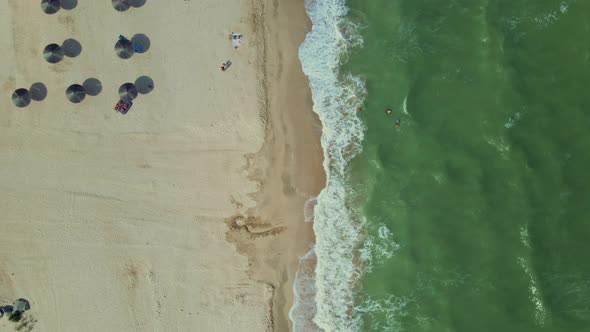 Aerial Top Down View To Sandy Seaside with Straw Sun Umbrellas