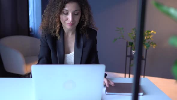 Attractive Adult Woman Working with Laptop in a Cozy Coworking Workspace