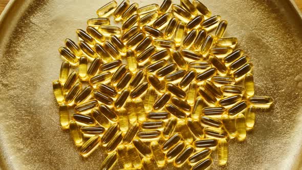 Fish Oil Capsules on a gold background.Rotation.Fish oil capsules background.