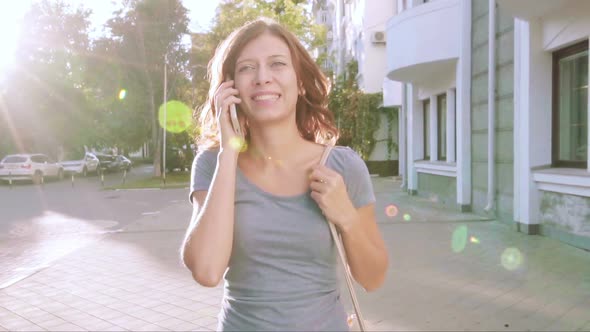 Young Woman With Smartphone Walking In The City