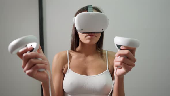 Excited Slim Young Woman in VR Headset and Underwear Gaming Online Standing Indoors