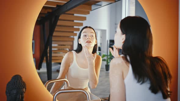 Young Pretty Lady with Skin Pigmentation Looking at Mirror at Home Enjoying Appearance Tracking Shot