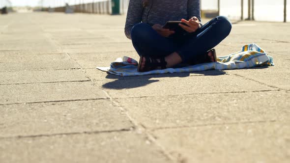 Girl using digital tablet at beach