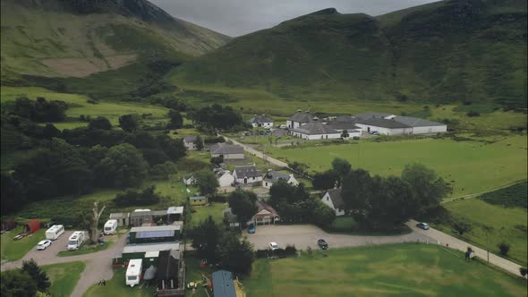 Scottish Arran Whiskey Distillery Aerial View Along Road in Greenery Valley with Mountains in Summer alt