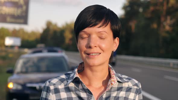 Girl with Black Hair Standing on the Roadside.