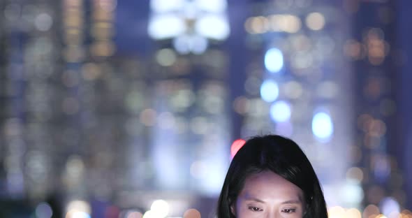 Young Woman use of mobile phone in Hong Kong at night